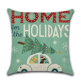 Cushion cover with Christmas-themed design featuring a car with a Christmas tree on top, in green, red, and white colors.