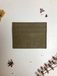 Olive green leather card holder with two card slots and stitched detailing.