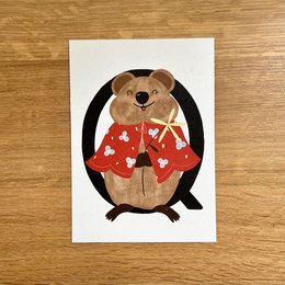 Cute plush quokka character in red floral outfit on greeting card.