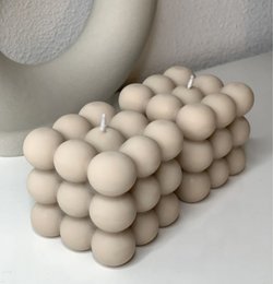 Beige bubble candle made of wax, with a unique spherical shape and textured surface, creating a visually appealing and decorative piece for any home.