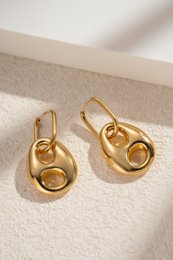  Sculptural gold-tone drop earrings with open circle design, crafted from stainless steel for a chic, trendy look.