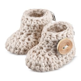 Soft, cozy baby booties in a variety of neutral colors including cream, dusty pink, grey, light blue, mint, and beige. Sizes range from 0-3 months to 6-9 months. The booties feature a chunky, crocheted design with a wooden button accent.