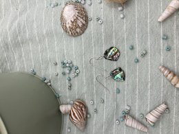 Silver handmade drop earrings with abalone shell and surfer-inspired vibe. Features natural shells, pearls, and beads in a neutral color palette.