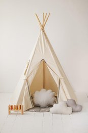 A cozy, grey teepee with white pompoms and a matching mat set, perfect for kids' indoor play and imagination.