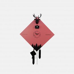Black Forest cuckoo clock with salmon and black accents, featuring a deer silhouette and pine tree design on a red diamond-shaped background.