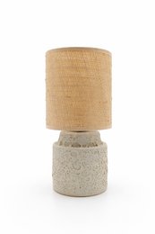 Stoneware table lamp with chic patina finish, featuring a cylindrical lamp base and a neutral-toned fabric shade.
