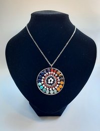 Colorful mandala-style necklace with a variety of beads in different shapes and sizes, including round, oval, and irregular shapes in various colors such as red, orange, yellow, green, blue, and purple.