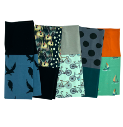 Arm warmers made of a cotton mix fabric, featuring various patterns including polka dots, geometric designs, and nature-inspired motifs like birds and trees. These versatile wrist warmers can be worn to add a stylish touch to any outfit.