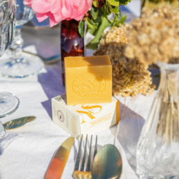Natural Immortelle de Corse artisanal soap bar, yellow in color, with a stamp design on the surface.