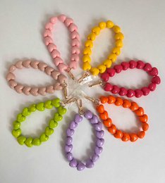  Colorful beaded phone cord with heart-shaped beads in various pastel shades including fuchsia, light pink, lavender, beige, yellow, apple green, and orange. The cord has a metal charm or pendant attached.