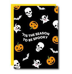'Tis the season to be spooky! This Halloween card features a pattern of skulls, bats, and jack-o'-lanterns against a black background, creating a festive and eerie atmosphere. The text on the card reads "Tis The Season To Be Spooky", perfectly capturing the spirit of the holiday.