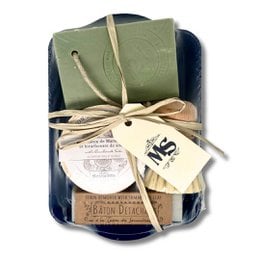 A gift box containing a soap bar, brush, and other items for Valentine's Day. The box has a rustic, natural aesthetic with a neutral color palette.