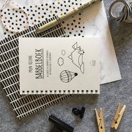 A spiral-bound notebook with a simple, hand-drawn design featuring a cloud-like shape and the text "Mijn kleine dagboek" (My little diary) on the cover. The notebook appears to be for children or young adults, with a minimalist, hand-drawn aesthetic.