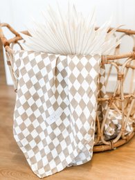  Soft, square baby blanket in a neutral sand-colored diamond pattern, made of high-quality muslin material.