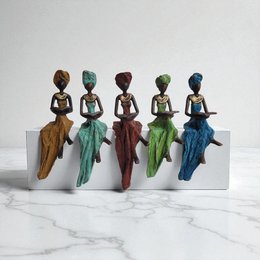 Bronze sculpture of a seated woman in various colors including blue, green, red, and turquoise. Unique handcrafted figurine.
