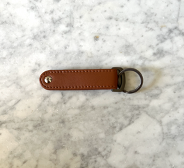 Brown leather keychain with bottle opener, Scandinavian design, suitable as a men's gift.