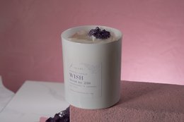 Tall, round, white scented candle with purple crystal accents. Made of natural wax and essential oils for a relaxing fragrance.