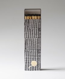 Extra long scented matches in a houndstooth pattern box. The matches are black and white in color, with a wooden tip. The box has a textured houndstooth pattern design.