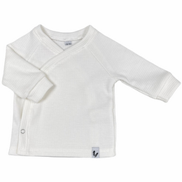 Ecru wrap-style baby shirt with long sleeves.