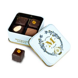  Light blue tin containing petit gourmet chocolate pralines in various flavors.