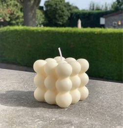 Ivory-colored, spherical bubble candle with a modern, minimalist design. Made of wax, suitable for use as a dinner or decorative candle.