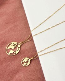 Gold and silver world map pendants in various sizes, featuring a minimalist globe design.