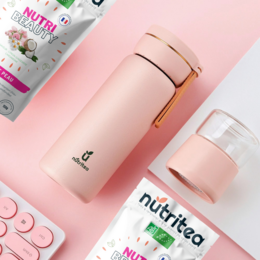 A pink and gold tea infuser with the product name "Infuzetea" and a light blue tea infuser with the brand name "Nutri tea" are shown in the images. The description should focus on the key product features such as color, material, and shape to enable effective semantic search.
Product Description: The Infuzetea tea infuser is a round, tall candle-shaped design available in rose, crème, bleu, and vert color variants. The Nutri tea infuser has a light blue, cylindrical shape with a metallic accent.