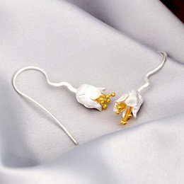 Detailed gold-plated sterling silver earrings with matte stamens, a statement accessory.
