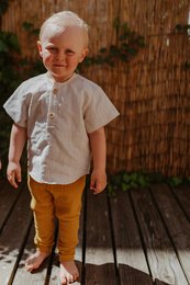 Linen t-shirt for kids in natural and dark caramel colors, available in sizes 74/80 to 122/128. The shirt has a simple, casual style with short sleeves.