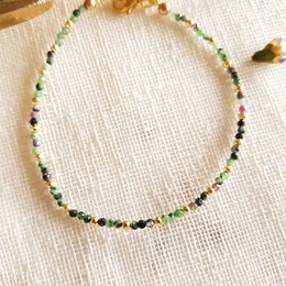 Bracelet with green, black, and gold beads. Delicate and stylish charm bracelet.