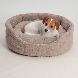  Plush, oval-shaped pet bed in beige color with raised edges for comfort. Suitable for small to medium-sized dogs. Dimensions range from 48x41x21cm to 76x67x27cm.