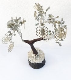 Decorative tree-like sculpture made of natural stones and crystals, featuring a central seed of life symbol, suitable for home decor or meditation.
