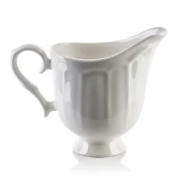 A white ceramic creamer with a classic, elegant design. The creamer has a tall, cylindrical shape with a curved handle and a spout for easy pouring. The smooth, glossy finish gives it a refined and sophisticated appearance, making it suitable for use in a variety of table settings.