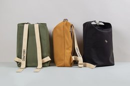 Durable backpack in black, green, and yellow colors with a minimalist design and sturdy construction.