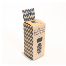 Biodegradable dental floss in a checkered paper packaging. The floss is made of natural materials and is designed to be environmentally friendly.