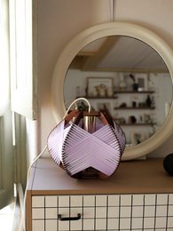 Small lilac table lamp with electrical cords for ceiling or tabletop placement.