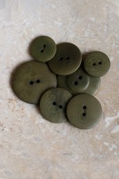 Ivy green round buttons, natural material, two-hole design, multiple sizes available for sewing and crafts.