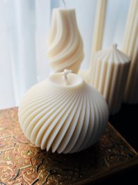Spiral-shaped, white pillar candle with a textured, pleated design.