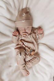  Cozy sand-colored ribbed jersey baby suit with a soft, plush texture and a comfortable hooded design.