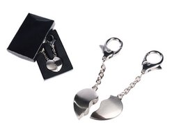 A broken heart-shaped keychain made of metal with a clasp for attaching to keys.