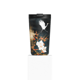  A ceramic mug with a black background and a white crane in flight, surrounded by colorful floral designs. The mug has a capacity of 350 ml.
