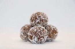 Energy balls made with cranberry and acai, in bulk 1kg size. Spherical shape, brown color, coated in coconut flakes.