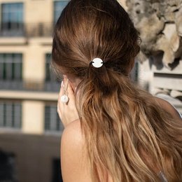 Scrunchie with a pearl accent, made of soft fabric, suitable for casual or formal wear.