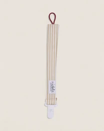Striped fabric pacifier clip with loop attachment, neutral beige and white vertical stripes, minimalist design.