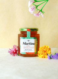  A jar of honey from the Provence region, featuring a vibrant floral design and a green and white label.