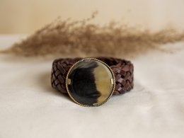 Small brown leather belt with a metal buckle, packaged in a polka dot gift box.