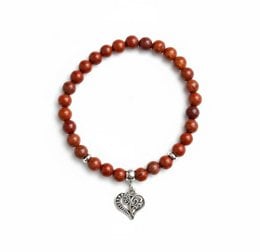 A red jasper beaded bracelet with a dream catcher charm, featuring round 6mm beads in a vibrant red color.