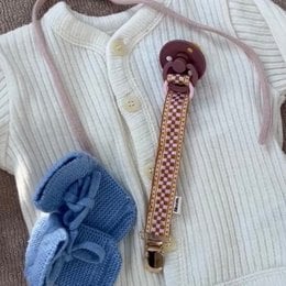 "Malibu pacifier clip with burgundy round bead, checkered pink and beige pattern, soft fabric attachment for babies."