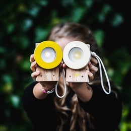 Yellow and white handheld flashlight with wrist strap, suitable for educational or outdoor use.