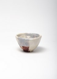 A round, black ceramic cup with a smooth, glossy finish and a light-colored interior.